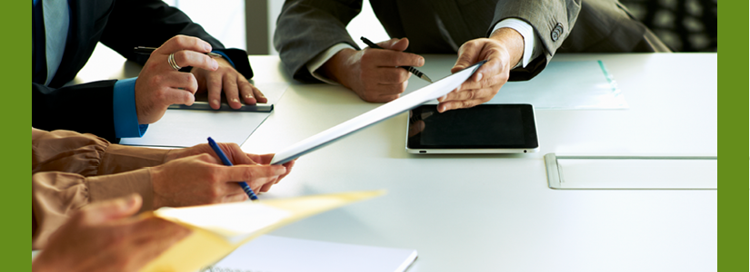 image close up of meeting - hands holding pens looking at a document